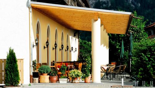 a patio area with a patio table, chairs, and umbrellas at Hotel Weinbauer in Schwangau