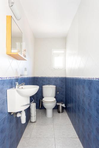 a blue and white bathroom with a toilet and a sink at Home2Book Relax Caletillas, Terrace & Pool in Candelaria