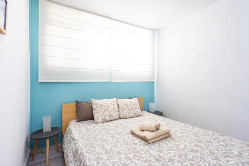 a bedroom with a bed with a blue wall at Home2Book Relax Caletillas, Terrace & Pool in Candelaria