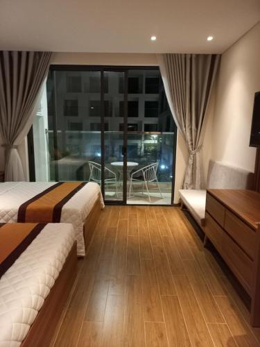 a hotel room with two beds and a balcony at Apec 5 sao TP.Tuy Hòa - View biển và view hồ bơi in Liên Trì (3)