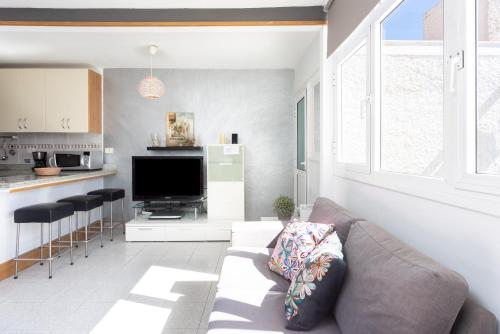 a living room with a couch and a tv at Home2Book Relax Caletillas, Terrace & Pool in Candelaria