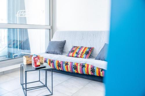 ein Sofa im Wohnzimmer mit einem Tisch in der Unterkunft LENA STUDIO - LA GRANDE MOTTE - PLAGE - CENTRE VILLE - 50m PORT - CONFORT in La Grande-Motte