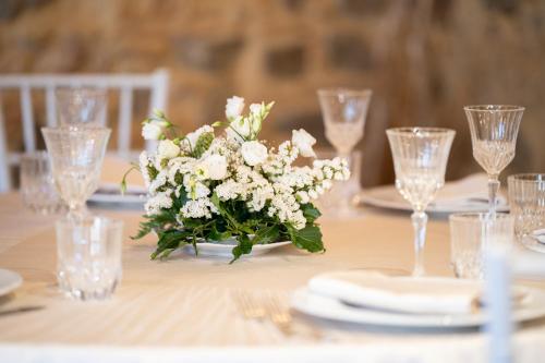 a table with a vase of white flowers on it at Tenuta Ciminata Greco in Rossano