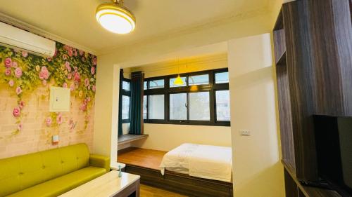 a room with a yellow couch and a bed and a window at 牧雲民宿 in Jinning