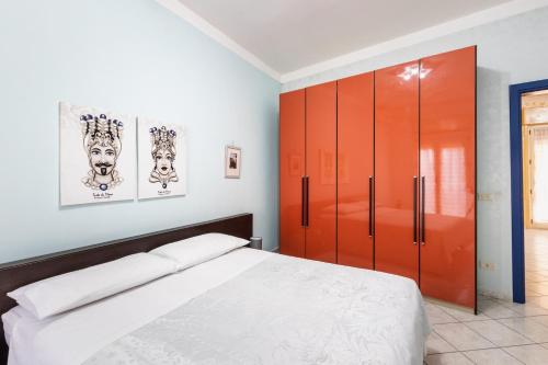 a bedroom with a bed and a orange cabinet at Corte dei Mori in Avola