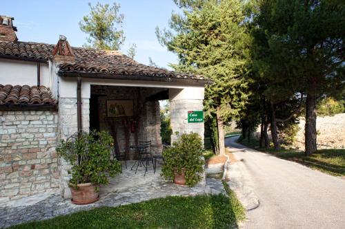 a small stone house with chairs and a street at Riserva Privata San Settimio in Arcevia