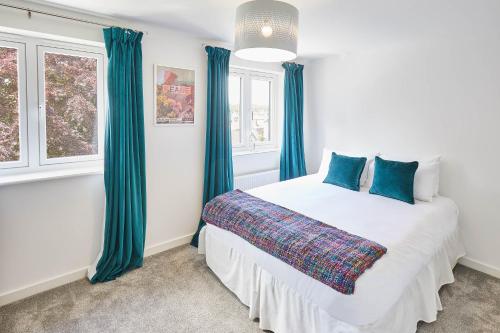 a bedroom with a large bed with blue curtains at Host & Stay - Castle View in Durham