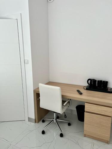 an office with a white chair and a wooden desk at Zielone Apartamenty Katowice Chorzów in Chorzów