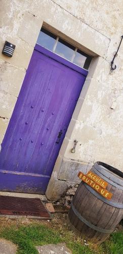 a purple door on the side of a building at Les Gîtes du Hameau avec piscine in Castelnau-sur-Gupie