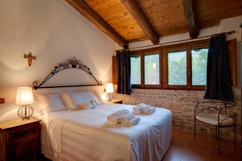 a bedroom with a large bed with towels on it at Riserva Privata San Settimio in Arcevia