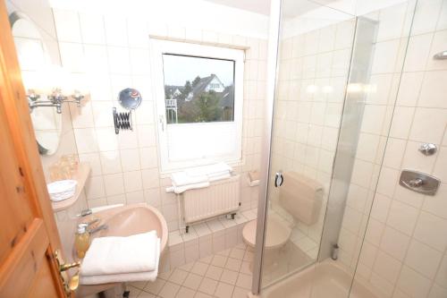 uma casa de banho com um chuveiro, um lavatório e um WC. em Enjoy-Sylt-1 em Westerland