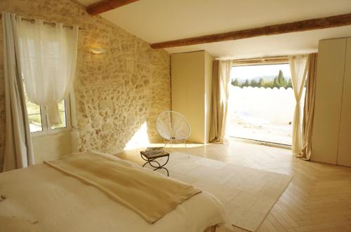une chambre avec un grand lit et une grande fenêtre dans l'établissement Superbe Mas en pierres de 350 m2 avec piscine pool house wifi parking gratuits, à Rochefort-du-Gard