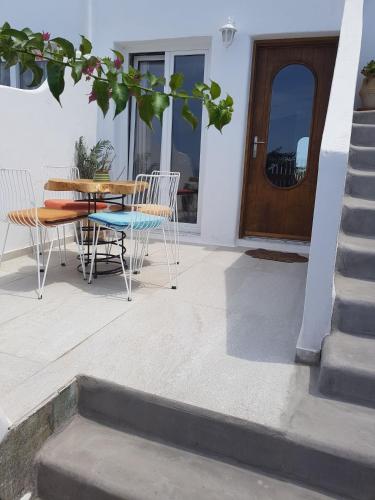 a patio with a table and chairs in front of a door at Villa Elina suites and more in Agios Stefanos
