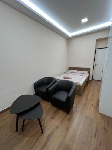 a room with a bed and a couch and a chair at 902 Apartments in Sarajevo