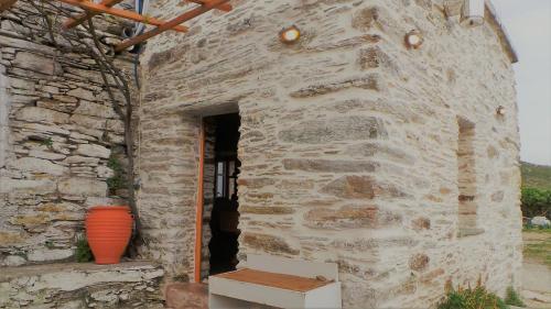 a stone building with an orange vase in the doorway at Konaki Hikers Lodge by Andros Routes in Andros