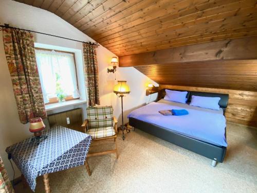a bedroom with a blue bed and a wooden ceiling at Ferienwohnung Kehlsteinblick in Schönau am Königssee