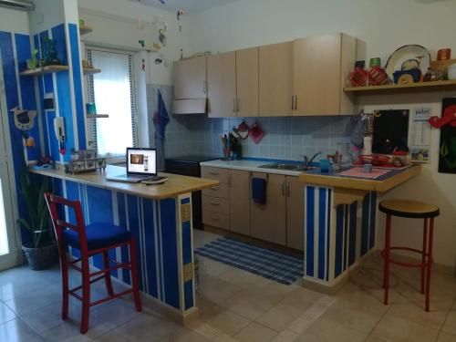 una cocina con una isla en el medio. en Sea and Relax in an artist house, en Muravera