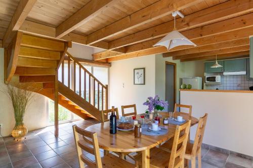 une salle à manger avec une table en bois et un escalier dans l'établissement Ty Lann, à Telgruc-sur-Mer
