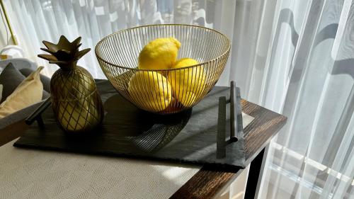 a bowl of lemons and a vase on a table at Vytauto 80 in Palanga