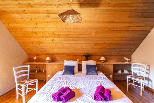 ein Schlafzimmer mit einem Bett mit lila Handtüchern darauf in der Unterkunft Ty Tevenn in Telgruc-sur-Mer