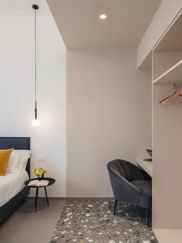a bedroom with a bed and a chair and a table at Living u HomeSuites in Lecce