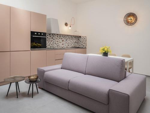 a living room with a couch and a kitchen at Living u HomeSuites in Lecce