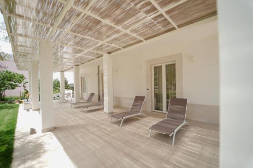 a group of chairs sitting on a patio at ALMASOL - Charme Experience in Castellana Grotte
