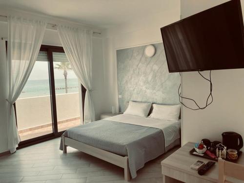 泰爾莫利的住宿－CARFAGNINI ROOMS，一间卧室配有一张床,享有海滩美景