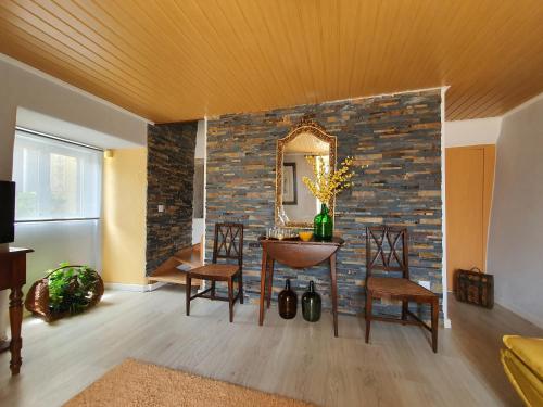 a living room with a stone wall and a table and chairs at Julia Old Village by Lisbon Village Apartments in Terrugem