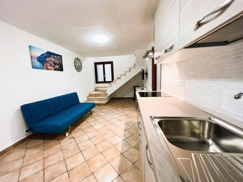 a kitchen with a blue couch in a room at Villa del Moro, FREE WIFI, 300mt from Sinzias' Beach in Costa Rei