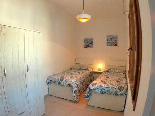 una camera con due letti e uno specchio di Appartamento Marina a Portoferraio