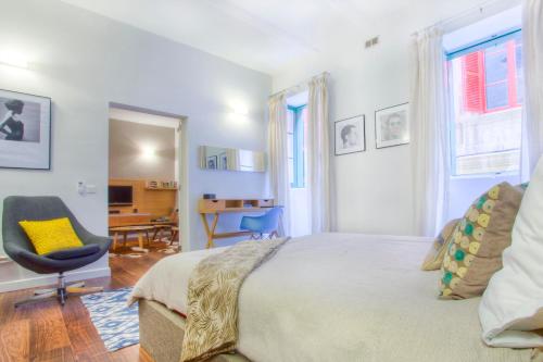 um quarto com uma cama, uma cadeira e uma secretária em Premium Design Central Suite em Valletta