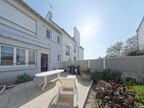 une terrasse avec une table et deux chaises devant une maison dans l'établissement Studio rénové proche plages et bourg - Port-Louis, 2 pers., RDC, Wi-Fi, jardin commun - FR-1-349-108, à Port-Louis