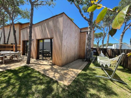 a wooden house with a deck and a hammock at Apartamentos Biopasivos Living Pura Madera in Chiclana de la Frontera