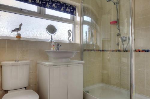 a bathroom with a toilet and a sink and a shower at Sandpiper in Lyme Regis