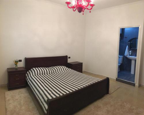 a bedroom with a bed and a sink and a chandelier at Julton Events Hotel in Domje
