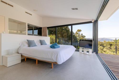 ein Schlafzimmer mit einem weißen Bett und einem großen Fenster in der Unterkunft Nature Villa in Alcúdia