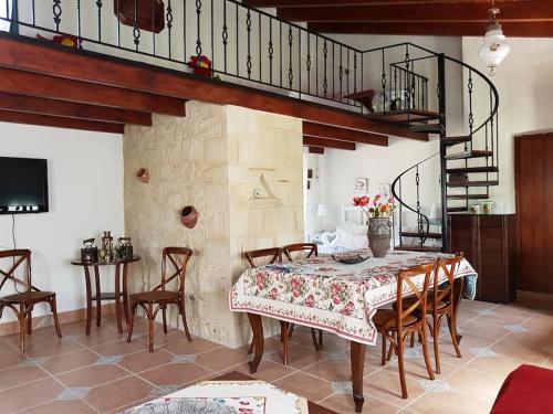 un comedor con mesa y sillas y una escalera en Vivian's House for relaxing holidays in Nature, en Kissamos