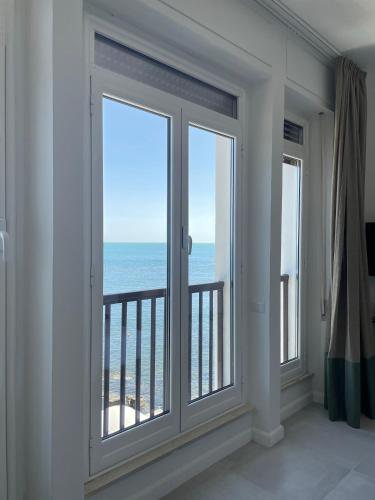 a room with windows with a view of the ocean at Villa delle Palme in Santa Marinella