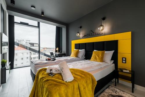 a bedroom with a large bed with a yellow headboard at Q18 ApartHotel in Bydgoszcz