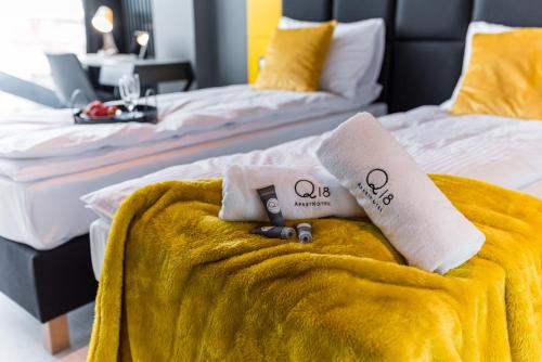 two beds with towels on top of each other at Q18 ApartHotel in Bydgoszcz