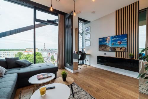 a living room with a couch and a tv at Q18 ApartHotel in Bydgoszcz