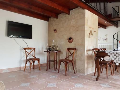 a living room with a table and chairs and a tv at Vivian's House for relaxing holidays in Nature in Kissamos