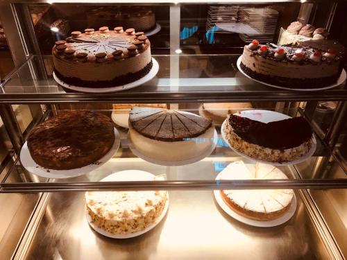a refrigerator filled with different types of cakes at Hotel Häußler in Langenbruck