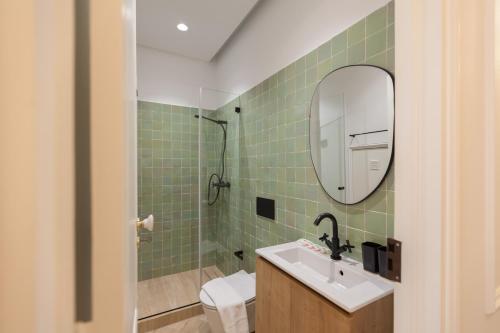 a bathroom with a sink and a mirror and a toilet at FLH Lapa Apartment with Interior Pateo in Lisbon