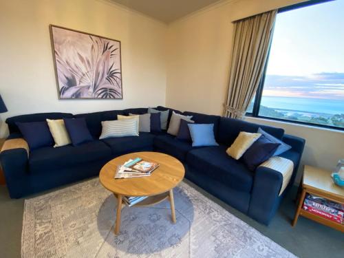 a living room with a blue couch and a table at Wirrina Cove Apartment in Wirrina Cove
