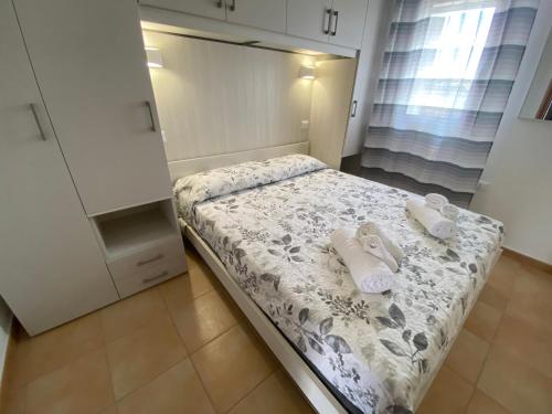 a small bedroom with a bed with towels on it at VILLA CHANTAL in Lampedusa