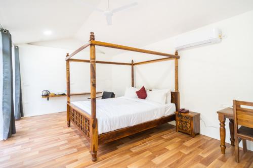 a bedroom with a wooden four poster bed at The Ayali Riverside Resort in Rishīkesh
