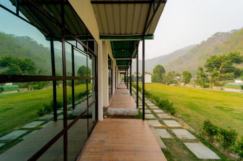 an outside view of a building with mountains in the background at The Ayali Riverside Resort in Rishīkesh