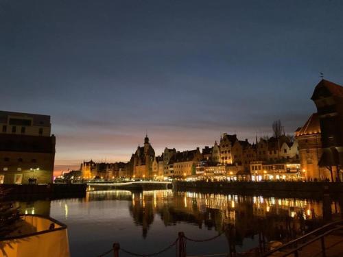 a city at night with a river and buildings at MB Boutique Apartment Gdansk in Gdańsk